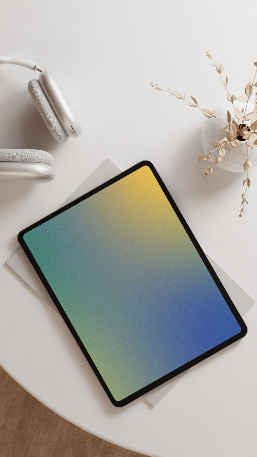 Green, blue, yellow gradient background mockup of ipad on a white table