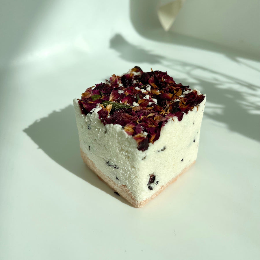 Rose and Lemon bath bomb cube with dried rose petals on top by Live Like You Green It pictured on a white background