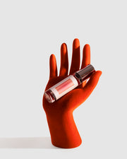 Shocks of Love Orange Blossoms Body Oil Roller Displayed on a Red Mannequin Hand